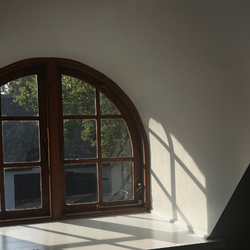 Buet vindue med varmt sollys, der falder ind i et stille lokale – stemningsfulde rammer der understøtter ro, fordybelse og nærvær på Tobias‑Skolens psykoterapeutuddannelse, kurser og efteruddannelser.