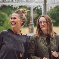 To personer i nærværende dialog i lyse, grønne omgivelser – stemningsbillede der viser ro, fordybelse og fællesskab på Tobias‑Skolens psykoterapeutuddannelse, kurser og efteruddannelser.