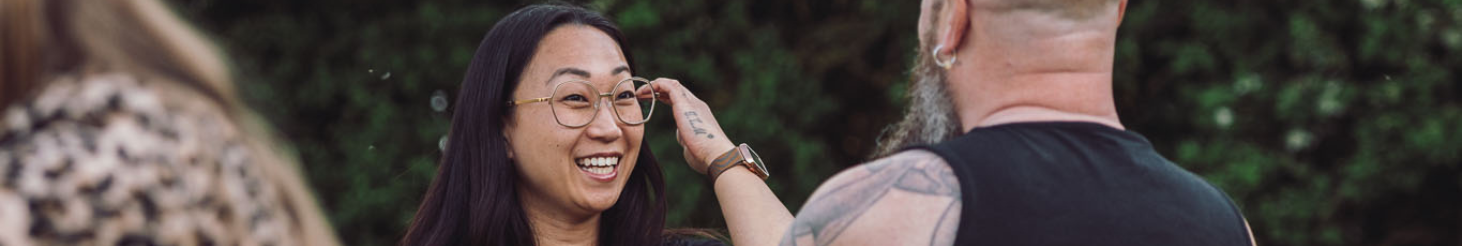 To personer sidder i græsset i rolige, grønne omgivelser og deltager i en nærværende samtale – illustrerer tryghed, relationel kontakt og personlig udvikling på Tobias‑Skolens psykoterapeutuddannelse, kurser og efteruddannelser.