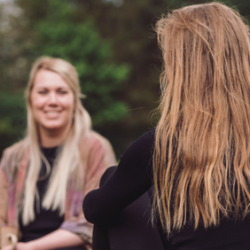 To personer i nærværende samtale i grønne omgivelser – stemningsbillede der viser fordybelse, tryghed og relationel kontakt som en del af Tobias‑Skolens psykoterapeutuddannelse, kurser og efteruddannelser.