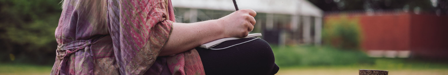 Person i rolig, nærværende kropsøvelse ved en udendørs pool – illustrerer grounding, selvkontakt og personlig udvikling som en del af Tobias‑Skolens psykoterapeutuddannelse, kurser og efteruddannelser.